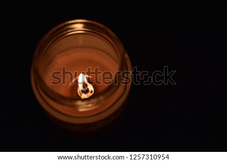 This is a picture of a candle lightning into the darkness in warm tones and focused on the fire.