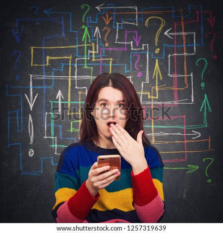Confused young woman using her phone shocked open mouth emotion. Human reaction concept as different colorful arrows and questions marks makes a maze with no answer. Problem analysis solution concept.