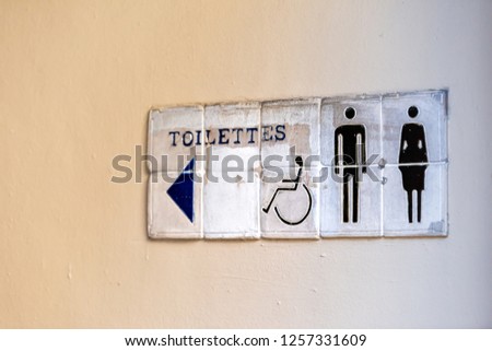 Restrooms bathroom toilettes French tiles sign on building wall on sidewalk closeup in town, city, nobody, architecture, symbol