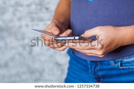 Close-up woman's hands holding a credit card and using smartphone for online shopping