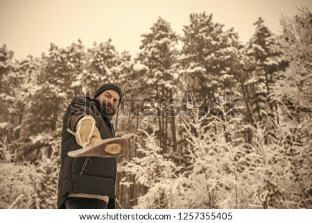 Bearded man with axe in snowy forest. Camping, traveling and winter rest. skincare and beard care in winter, beard warm in winter. Temperature, freezing, cold snap, snowfall. Man lumberjack with ax.