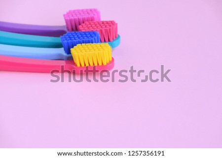 Colorful toothbrushes with selective focus on violet background. Toothbrush for personal routine morning  hygiene on neutral blurred backdrop. Dental plastic tool with empty space for image or text
