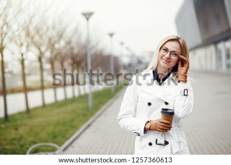 Cheerful girl in the street drinking morning coffee and  her smartphone. in the street drinking morning coffee and using smart phone.