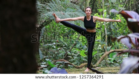 Yogi woman training Yoga asana balance pose outdoor in nature