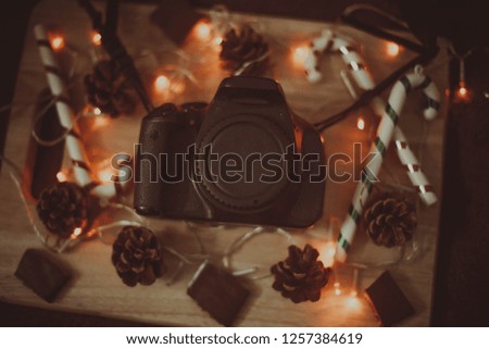 Christmas, New Year holiday background. Camera, christmas gifts. Christmas photocamera dslr with decorations. Digital Photography. Close up photo of  camera  over wooden table.