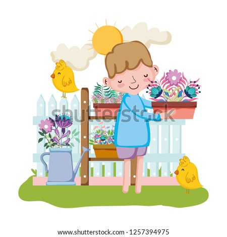 little boy lifting houseplant with fence and chick