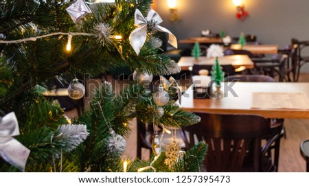 Christmas tree with silver balls, bows and a garland in a cafeteria, festive decor a cafeteria, holiday atmosphere, Christmas 2019, new year 2019, selective focus and copy space