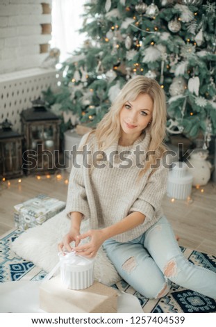 Happy blonde women in Christmas decorations with gifts