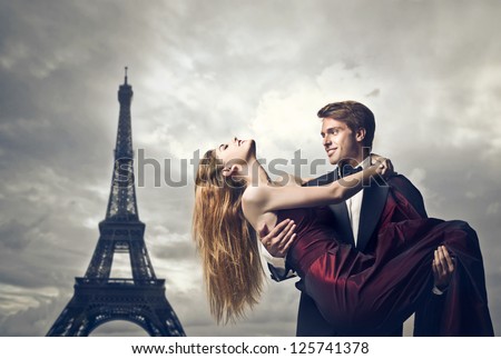 Elegant young lover holding her lover with the Eiffel Tower in the background