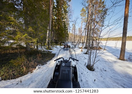 A man rides a snowmobile on forest and snow. Extreme outdoor activities in winter. Rear view of a man 