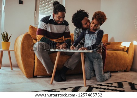 Shot of parents and kid painting pictures at home