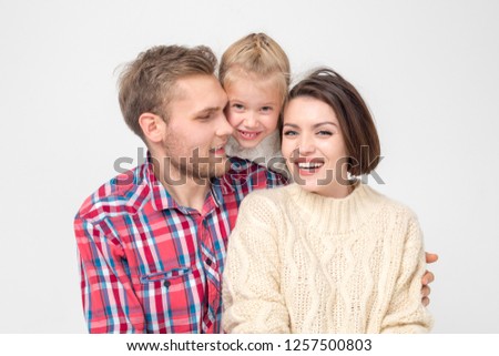 Happy family of three hugging on white background.