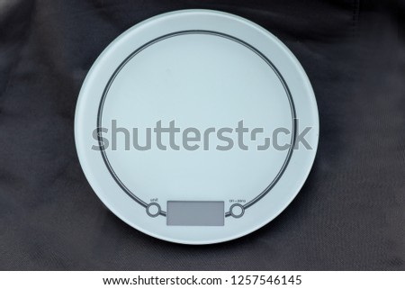Circular white ceramic scales isolated on a dark background
