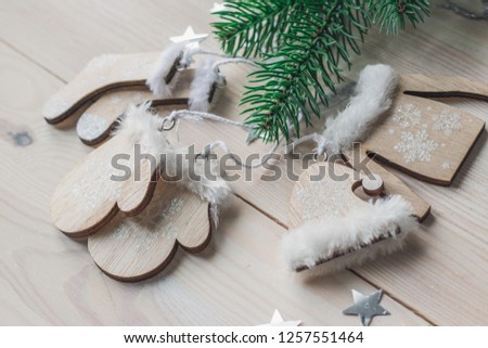 Wooden Christmas decorations on a white wooden background with a branch of a Christmas tree space for text