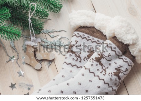 Wooden Christmas decorations and Christmas socks on a white wooden background with a branch of a Christmas tree space for text