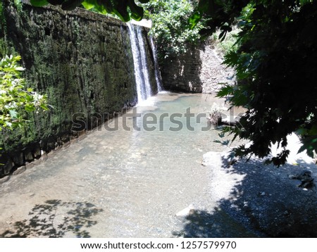 river flowing over the ancient wall in the forest

