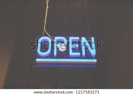 A business sign that says ‘Open’ on cafe or restaurant hang on door at entrance. Vintage color tone style.