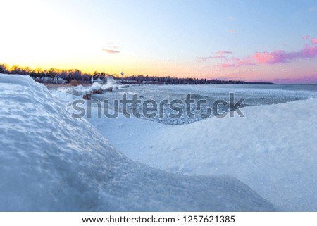 Winter Beach Sunrise Background. Snowy beach and icy sunrise on the shores of Lake Huron in Michigan.