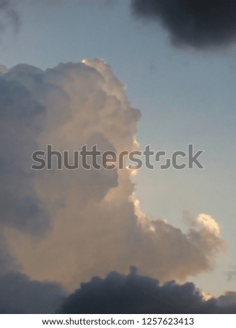 picture in portrait format, cumulus cloud, large, with gray shadows and edges illuminated by sunlight, bordered by dark clouds, sao paulo, Brazil