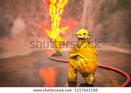 firefighter training., fireman using water and extinguisher to fighting with fire flame in an emergency situation., under danger situation. with copy space.