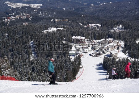 On the white slopes of Pamporovo, a ski resort in Bulgaria, skiing people and hotels
