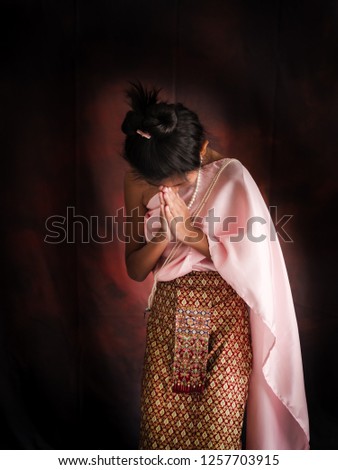 Asian girl wearing Thai Costume with dark background.