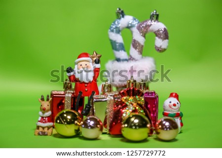 Santa claus reindeer and snowman doll with gift box on green background. Merry christmas.