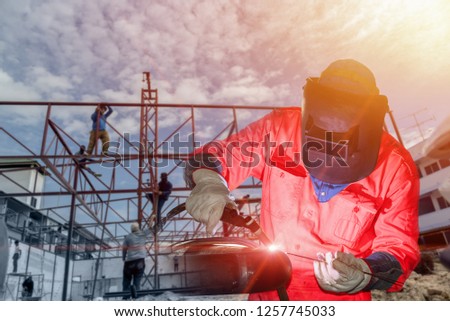 Male welding worker Construction wearing protective equipment on structural background