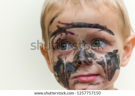 
a little cute little boy with a painted face, paints of dark colors, a portrait