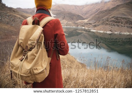 Close-up from the back girl traveler on the background of the lake in the mountains