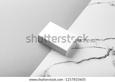 Photo of white business cards on white marble and gray background. Mock up for branding identity isolated on marble background. Business Card mock-up isolated on marble stone 