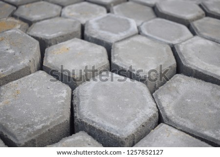 Close up to grey pavement bricks those were produced in hexagon shape.