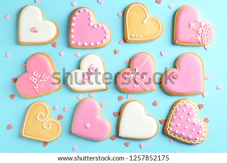 Composition with decorated heart shaped cookies on color background, top view. Valentine's day treat
