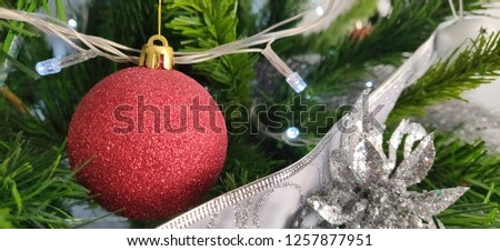 red christmas bulb decorarion with silver lights and winter flower