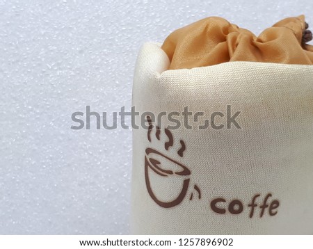 Fabric bag with picture of a cup and misspelled word "coffe" on white background.Copy space.Education concept.English language study concept.