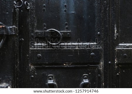 Closeup view of details of old black door. Horizontal color photography.