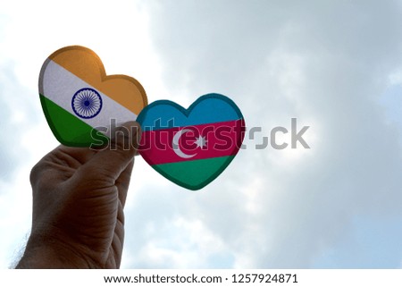 Hand holds a heart Shape India and Azerbaijan flag, love between two countries