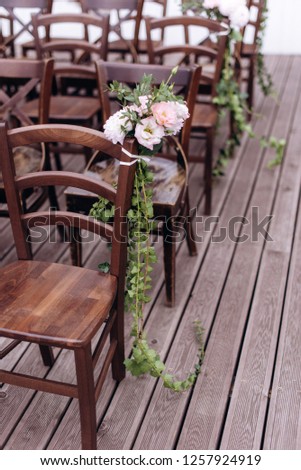 Outgoing wedding ceremony. Decor Studio. brown wooden chairs on a green lawn. Wedding festal arch. White armchairs for guests