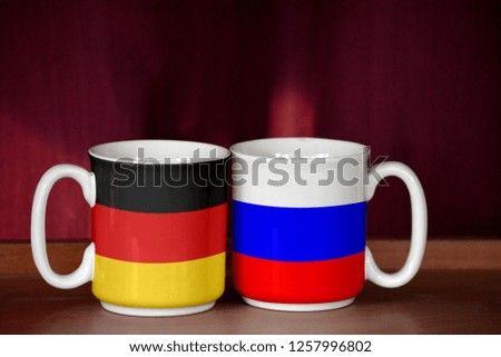 Russia and Germany flag on two cups with blurry background