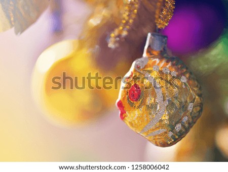 Beautiful Christmas tree fish bauble on blurry background. Winter holiday light decoration closeup