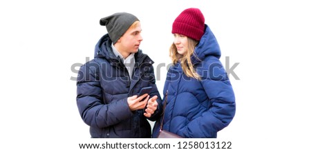 young man and woman coupe outdoors isolated on white background using a smartphone showing pictures