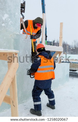 Workers build an ice town from ice blocks for the Christmas holidays