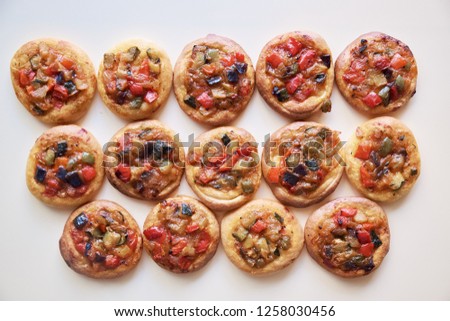 Top view of freshly baked mini pizzas Cocas in Spain. Traditional Spanish pastry with vegetables .
