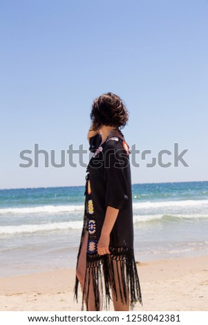 Beautiful young woman on the beach in summer. Black sea and blue sky