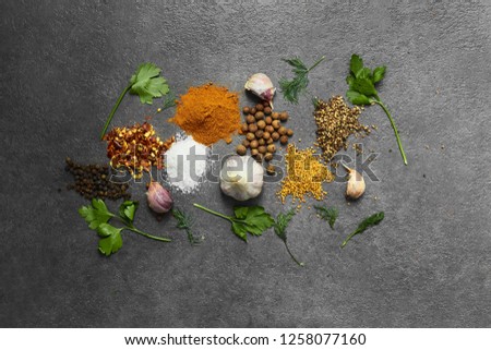 Selection of spices, herbsl on black stone table. Ingredients for cooking. Food background. Top view with copy space.