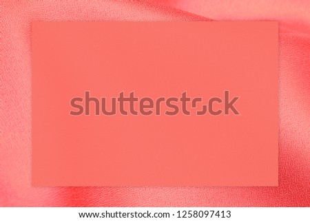 Living coral color frame on Soft pink orange cloth or satin cloth; copy space, text place 