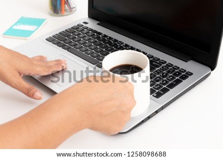 Workplace women working on a laptop and holding a cup of coffee on a white background. Copyspace