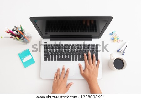Business woman type on laptop computer on white office desk, coffee, mobile phone , pen, and office plant, notebook, Accounting concept with copy space