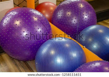 Sports balls for fitness of different sizes next to the mirror in the sports club