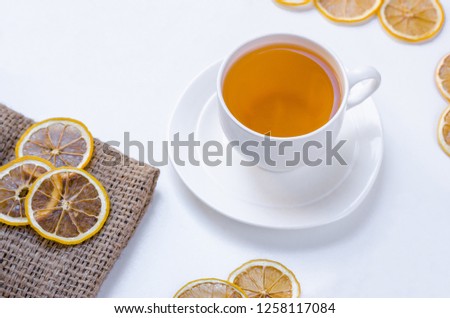 Orange herbal flavored christmas tea with cinnamon and cardamom honey white cup on a white wooden table 